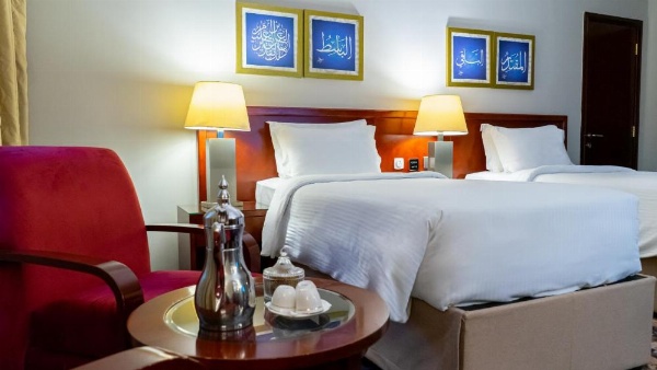 Twin beds with red armchairs at Al Safwah Hotel Third Tower 3.